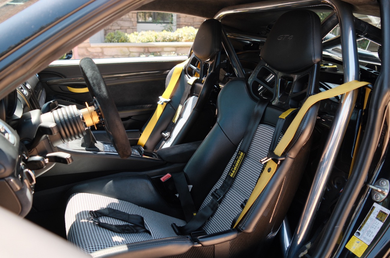 Porsche 718 GT4 cockpit with houndstooth seat inserts and yellow Schroth harnesses