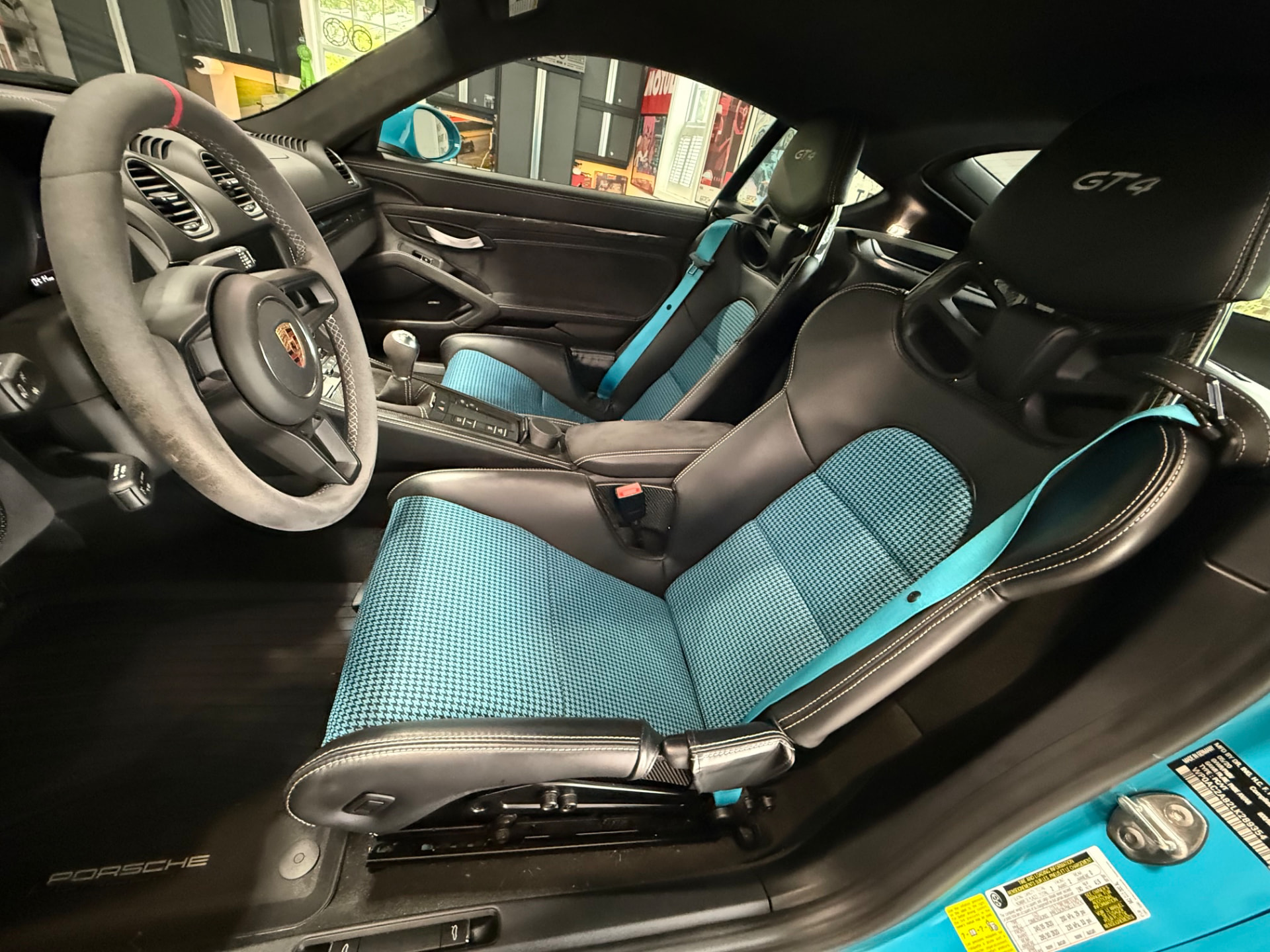 Porsche 718 GT4 cockpit with Miami Blue houndstooth seat inserts and matching harness webbing
