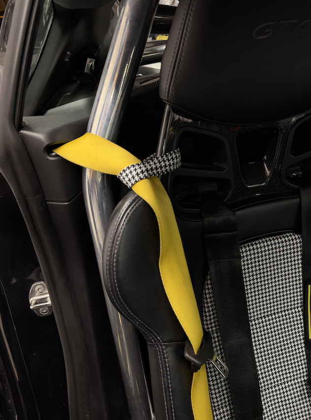 Houndstooth seat belt retainer strap on a Porsche bucket seat